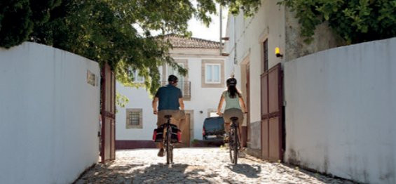 Cyclistes dans une ruelle blanchie à la chaux - Vallée du Douro - Portugal