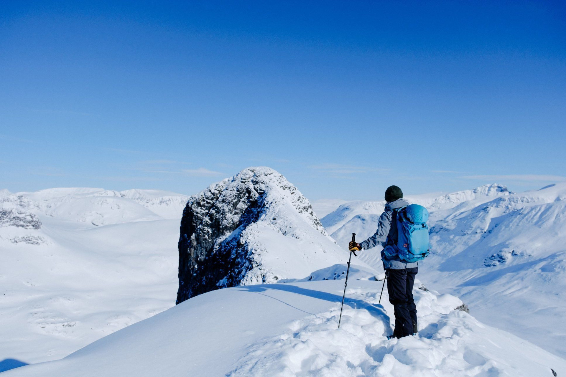 Randonneur à ski admirant les sommets enneigés - Jotunheimen - Norvège