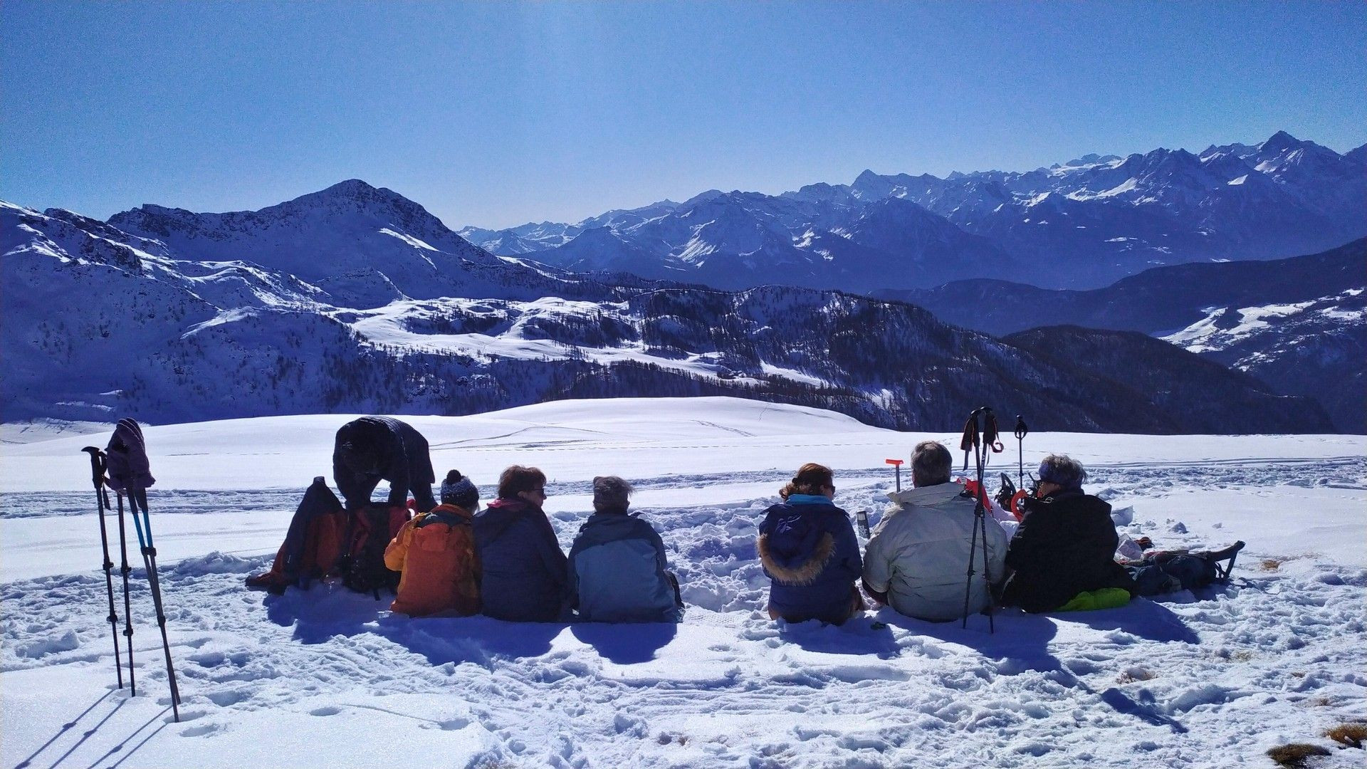 © Pierre Paillat Pause d'un groupe en raquettes face aux sommets enneigés - Alpes italiennes - Italie
